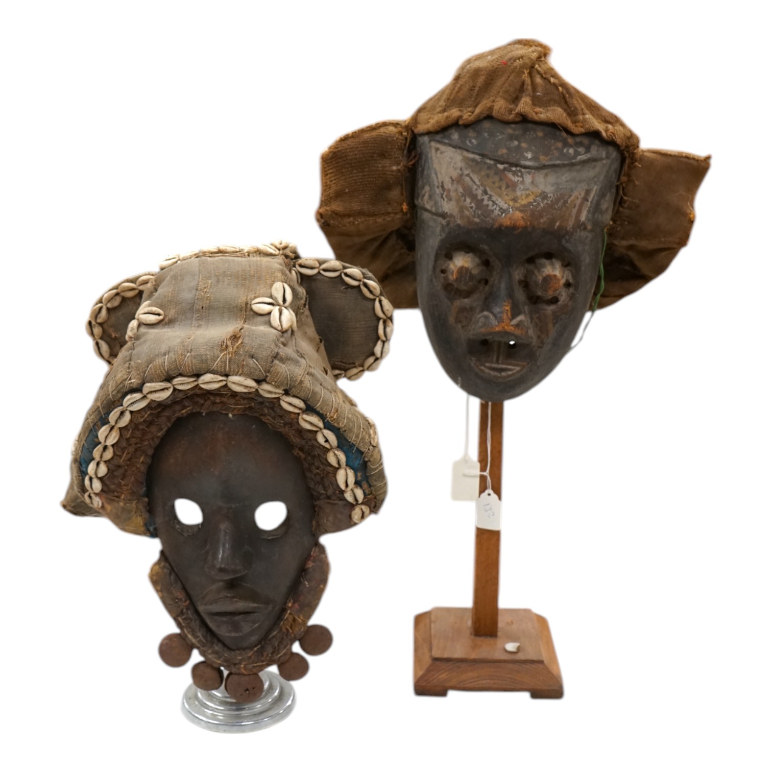 An African Ivory Coast/Liberian Dan mask together with another from the Democratic Republic Congo, both on stands, tallest 58cm including stand. Condition - some damage to the fabric of hats